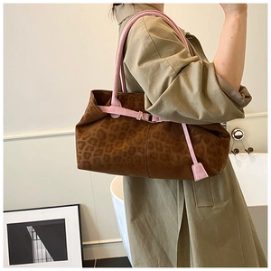 Detail shot of a leopard print tote bag featuring pink straps on model shoulder