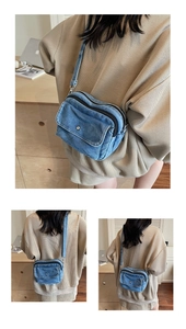 Detail of blue denim crossbody bag featuring double zippers and a front flap pocket
