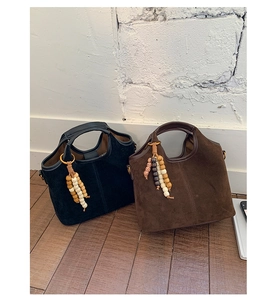 Détail de sacs cabas vintage en daim noir et marron foncé avec breloques perles
