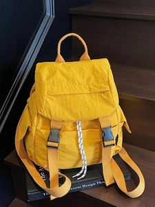 Mochila de nailon amarillo brillante con cordón para mujer en escalera de madera