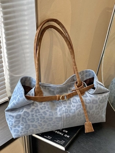Light blue leopard print tote bag with brown handles and decorative strap buckle