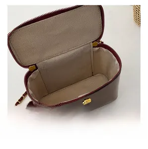Detail view of the spacious inner compartment with herringbone lining in a red crossbody bag