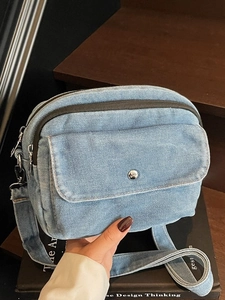 Light blue denim crossbody bag with multiple compartments and adjustable shoulder strap