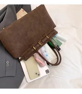 Flat lay showing large capacity of brown suede tote bag with daily essentials inside