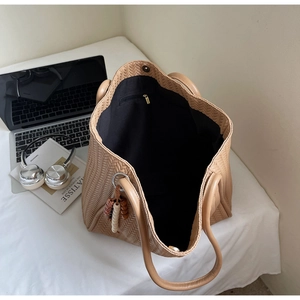 Makroansicht der khakifarbenen Webstruktur-Tasche mit Reißverschluss-Innentasche und Anhänger