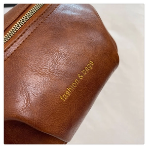 Macro shot of brown leather texture with fashion & bags embroidery on cross-body bag