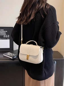 White lychee leather saddle bag with gold metal twist lock shown on a model