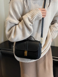 Vintage black lychee pattern underarm bag with gold buckle shown on a model