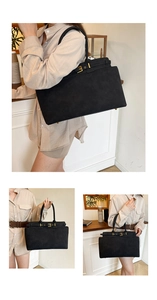 Detail of black matte leather tote bag with metallic buckle strap in a cafe setting