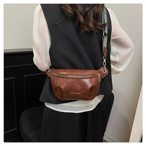 Detail of vintage brown leather crossbody bag with ethnic woven strap and gold hardware
