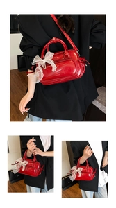 Detail der roten Lackledertasche mit weißem Spitzen-Schleifenanhänger und Trageriemen