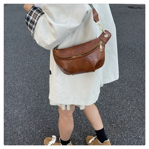 Detailed side view of a brown PU leather crossbody bag with ethnic style woven strap
