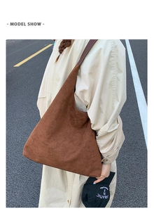 Deep brown matte suede tote bag shown on a model wearing a beige trench coat outdoors