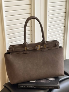 Large dark brown tote bag with decorative gold buckle shown against a white shutter background