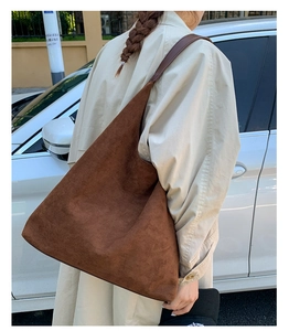 Detalle del bolso tote de ante marrón con gran capacidad y una textura mate elegante