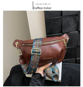 Close-up of dark brown crescent bag with lychee texture and ethnic patterned strap