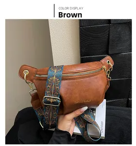 Detail of brown leather crossbody bag with vintage bohemian pattern shoulder strap