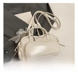 Detailansicht einer beigen Boston Bag mit Reißverschluss-Vortasche und Spitzen-Schleife