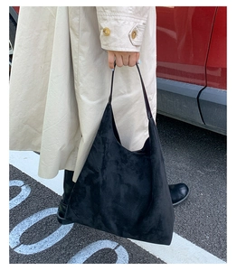 Detailed view of black matte tote bag showing the suede texture and shoulder strap