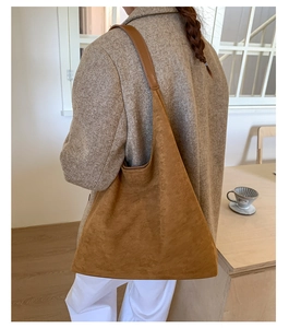 Bolso tote de ante marrón mate al hombro en un ambiente interior acogedor y sobrio