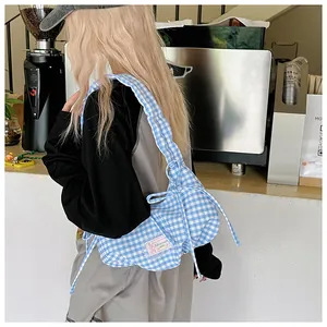 Detail of blue and white gingham canvas shoulder bag with decorative drawstring bow