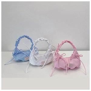 Close-up of pleated cloud bags in blue plaid, white, and pink stripes with bow detail