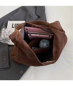 Internal view of a brown suede hobo bag showing large capacity for tablets and umbrella