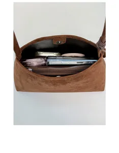 Interior view showing the large capacity and zipper pocket of this brown suede shoulder bag