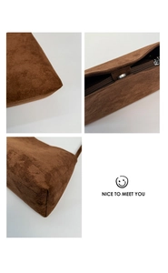 Detail of brown suede handbag showing stitching, magnetic snap and zipper closure