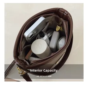 Vista macro della capacità interna di una borsa a secchiello in pelle marrone con oggetti