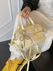 Cremefarbene Boston-Handtasche mit großer Netzschleife und silbernem Perlenanhänger