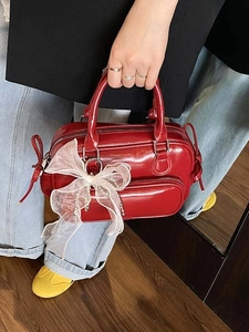 Modische rote Lackleder-Handtasche mit weißer Organzaschleife im Bowling-Taschen-Stil
