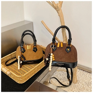 Close-up of quilted suede shell bags in tan and dark brown with boho bead charms
