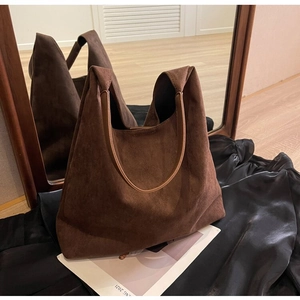 Detailed close-up of dark brown suede hobo tote bag with reinforced side stitching