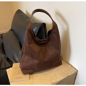 Detail view of large dark brown hobo shoulder bag with soft suede texture and wide strap
