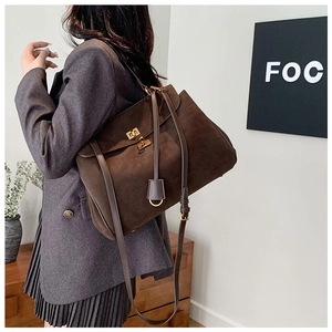 Détail d'un sac cabas en daim marron vintage avec boucle en métal doré et fini mat
