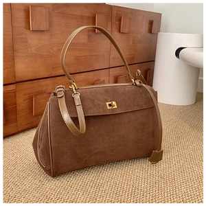 Détail du sac à main en daim marron avec boucle en métal doré et bandoulière réglable