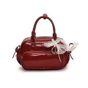 Mochila roja brillante con cadenas de perlas y lazo de encaje sobre fondo blanco