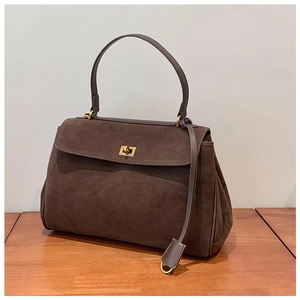 Détail du sac à main en daim marron vintage avec fermoir rotatif en métal doré chic