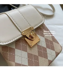 Close-up of golden metal lock and quilted pattern on a small crossbody bag