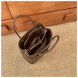 Vue de dessus montrant la texture tressée et la pochette rayée du sac cabas marron