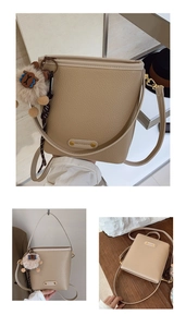 Dettaglio della borsa a secchiello in pelle beige con logo oro e ciondolo morbido