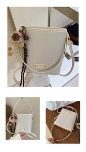 Dettaglio della borsa a secchiello in pelle grana litchi bianco panna con hardware oro