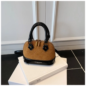 Close-up of camel suede shell bag with diamond quilting and black patent leather handles