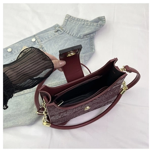 Détail intérieur du sac bordeaux texturé montrant la doublure et la poche zippée