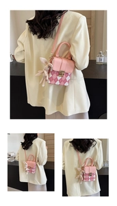 Detail showing pink argyle mini crossbody bag with a plush bunny charm and metal lock