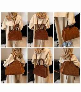 Detalle del bolso tote de ante marrón con asas reforzadas y costuras decorativas de calidad