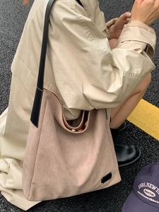 Grand sac cabas minimaliste en daim marron clair avec bandoulière en cuir sur l'épaule
