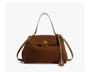 Détail du sac à main vintage en daim marron foncé avec fermoir rotatif doré élégant