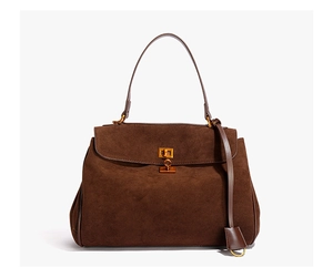 Détail d'un sac à main en daim marron foncé avec fermoir doré et texture mate élégante